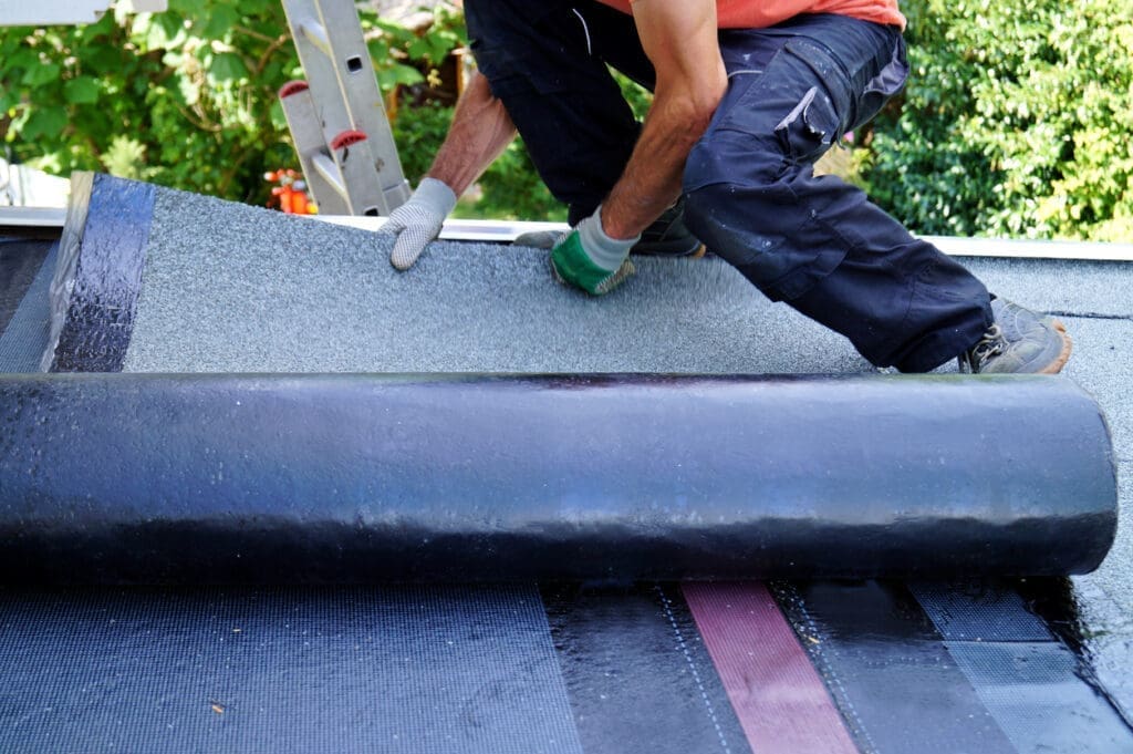 Contractor installing rooftop tar foil