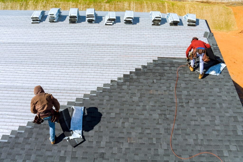Roofing contractors installing shingles