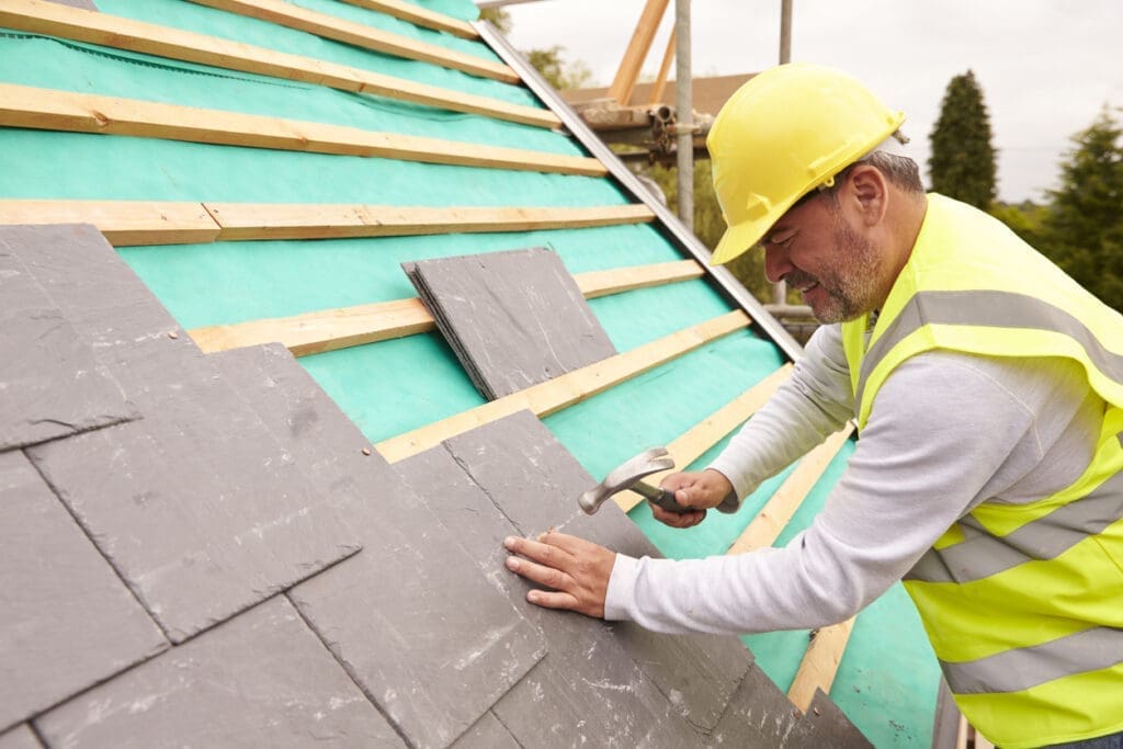 Contractor installing shingles
