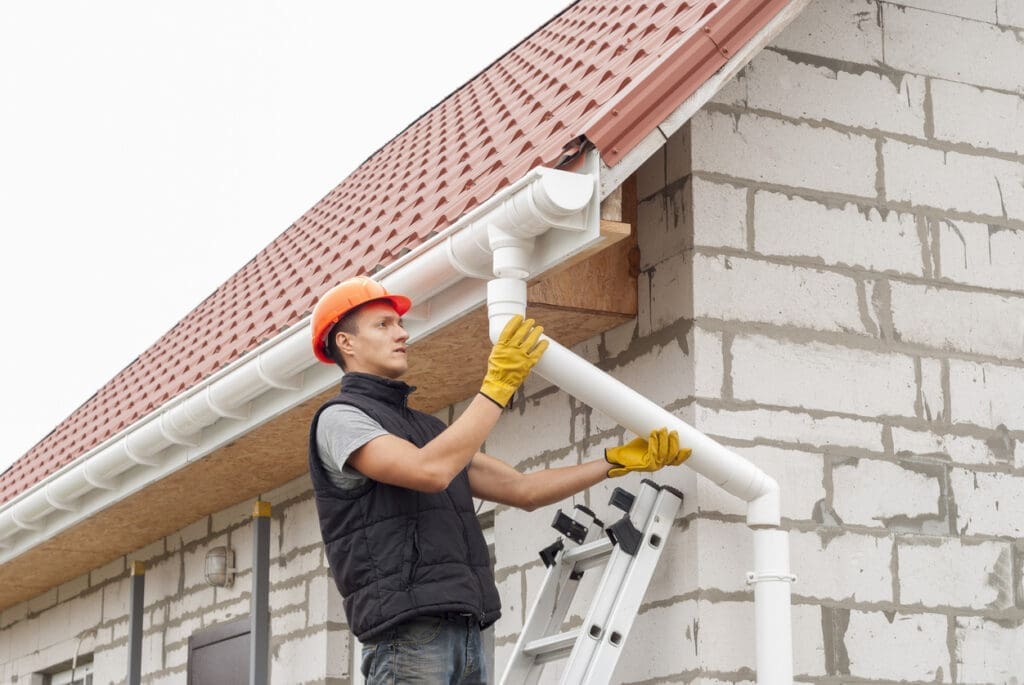 Contractor installing gutters