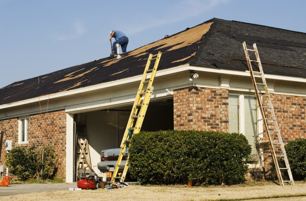 Roofers replacing shingles on residential home
