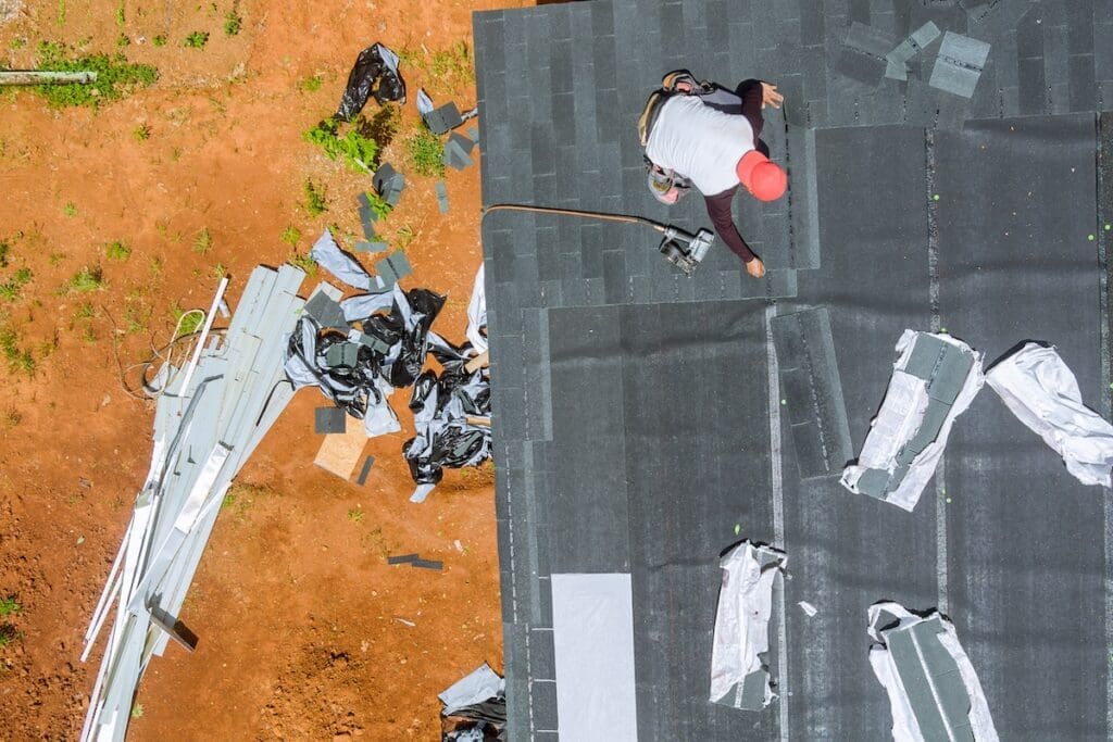 Roof replacement in progress in Bulverde, TX. An Eternal Roofing crew member installing new shingles on a residential home after storm damage.